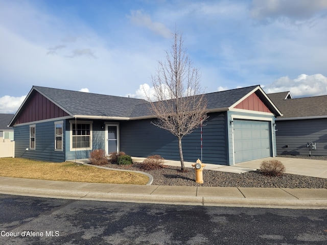 view of front of property featuring board and batten siding, driveway, a garage, and roof with shingles