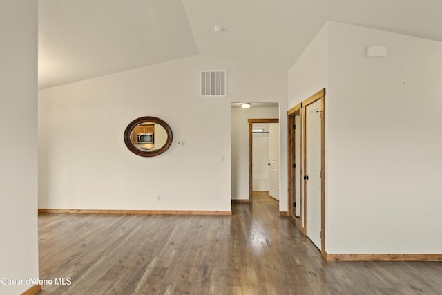 hallway with wood finished floors, visible vents, and baseboards