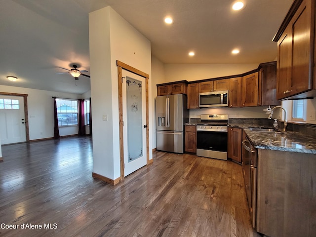 kitchen with dark wood-type flooring, a sink, stainless steel appliances, lofted ceiling, and ceiling fan