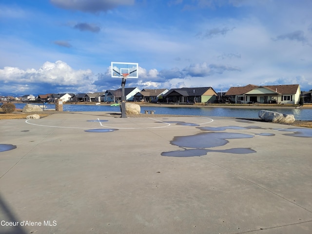 view of basketball court with community basketball court, a residential view, and a water view