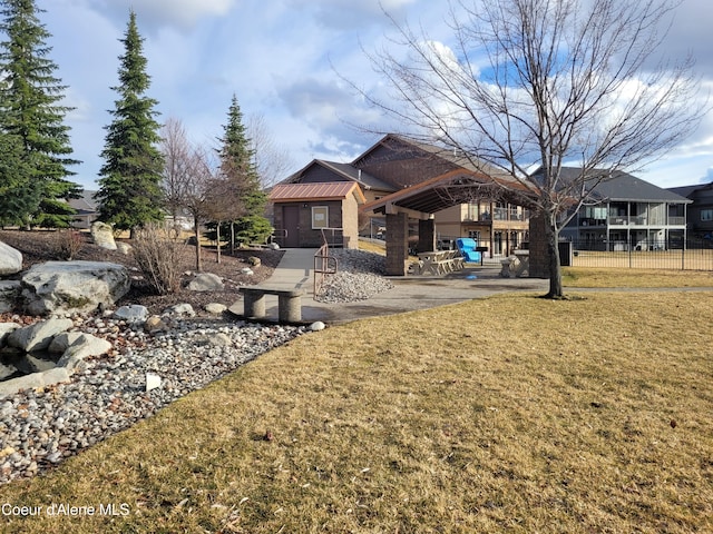 rear view of house featuring a yard and fence