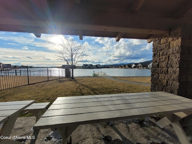 view of patio with fence and a water view