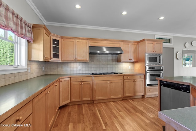 kitchen with under cabinet range hood, stainless steel appliances, ornamental molding, and light wood finished floors