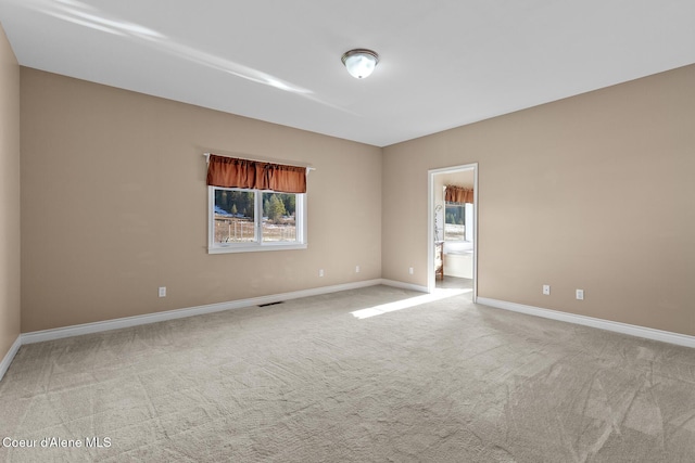 carpeted spare room featuring visible vents and baseboards