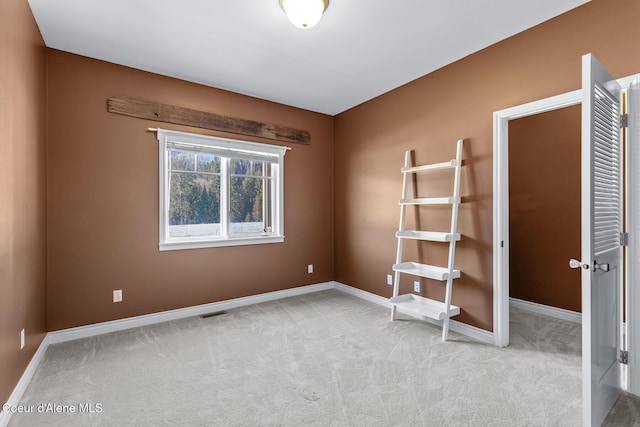 unfurnished bedroom with baseboards, visible vents, and light carpet