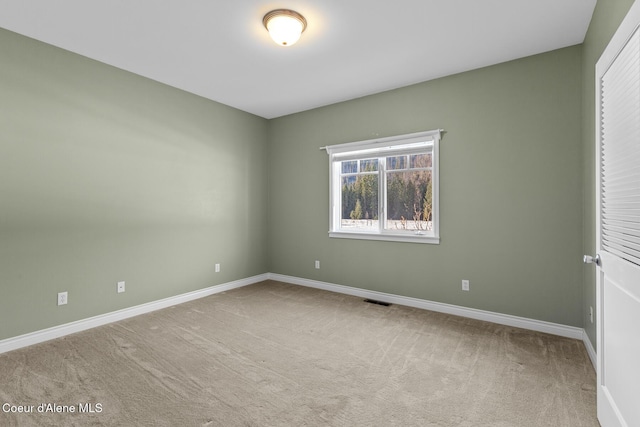 carpeted empty room with visible vents and baseboards