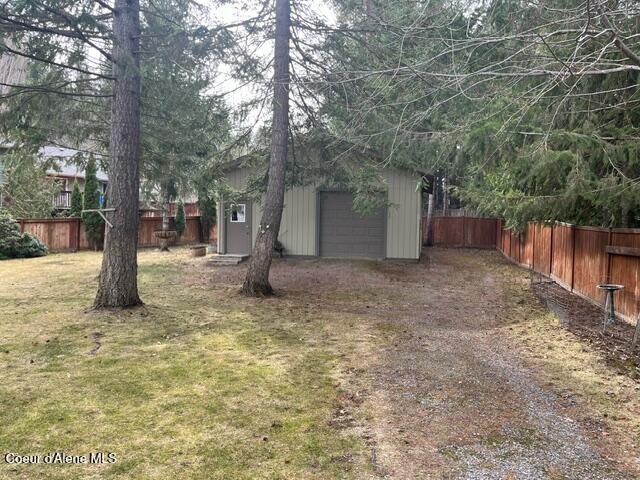 view of yard featuring an outbuilding and fence