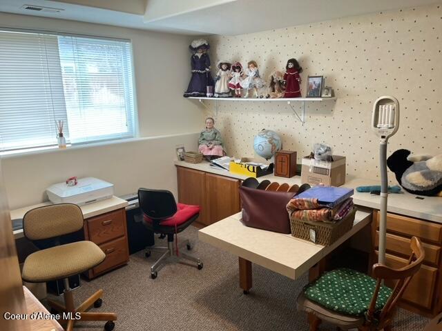 home office featuring wallpapered walls, visible vents, and carpet floors