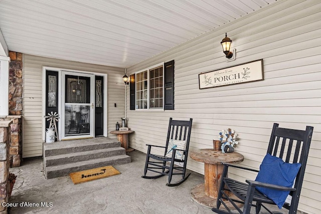 doorway to property with stone siding and a porch