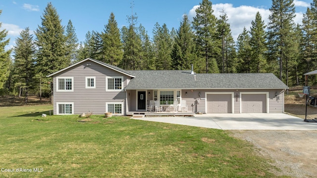 split level home featuring a porch, a front lawn, driveway, and a garage