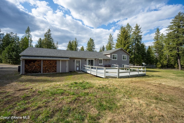 back of house with a wooden deck and a lawn