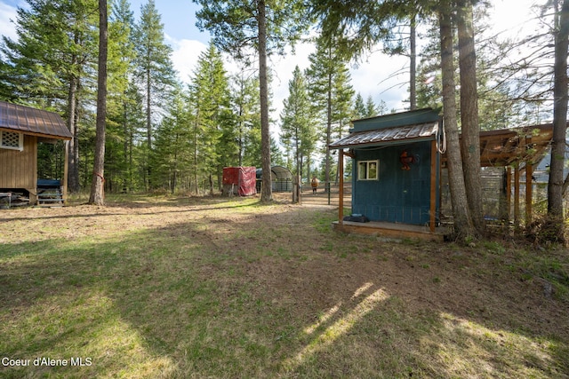 view of yard featuring a carport and an outdoor structure