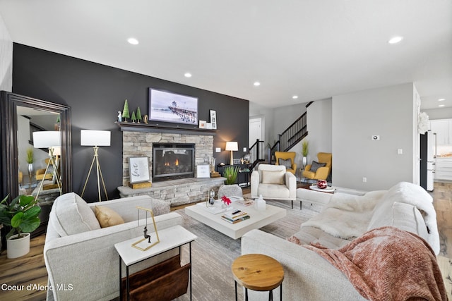 living room featuring stairway, recessed lighting, a fireplace, and wood finished floors