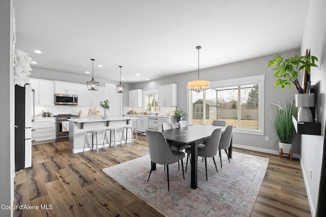 dining area with recessed lighting, baseboards, and wood finished floors