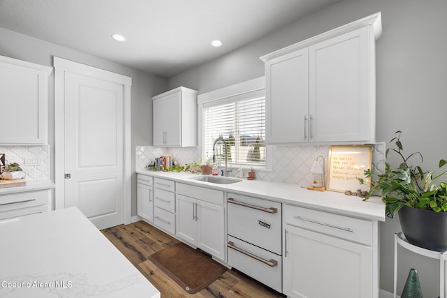 kitchen featuring recessed lighting, dark wood-style flooring, a sink, light countertops, and white cabinetry