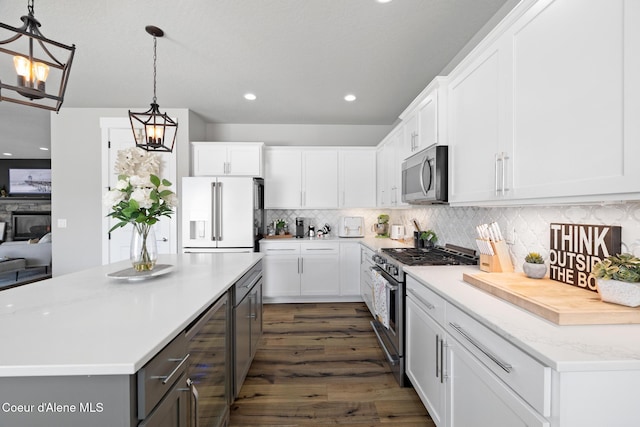 kitchen featuring tasteful backsplash, a kitchen island, wine cooler, appliances with stainless steel finishes, and white cabinetry