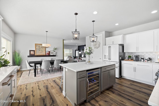 kitchen with backsplash, gray cabinetry, beverage cooler, dark wood finished floors, and high end fridge