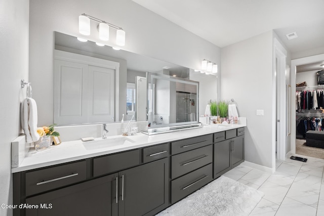 bathroom featuring visible vents, a shower stall, double vanity, marble finish floor, and a sink