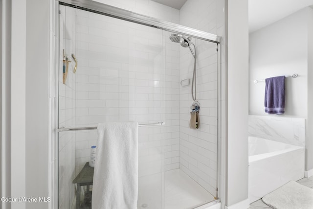bathroom featuring a bath and a shower stall