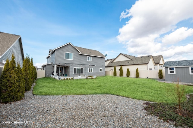back of house featuring a yard, a patio area, an outdoor structure, and a fenced backyard