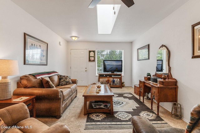 living area with light colored carpet, a skylight, and baseboards