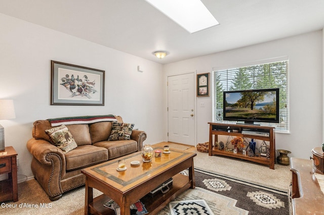 carpeted living area featuring a skylight