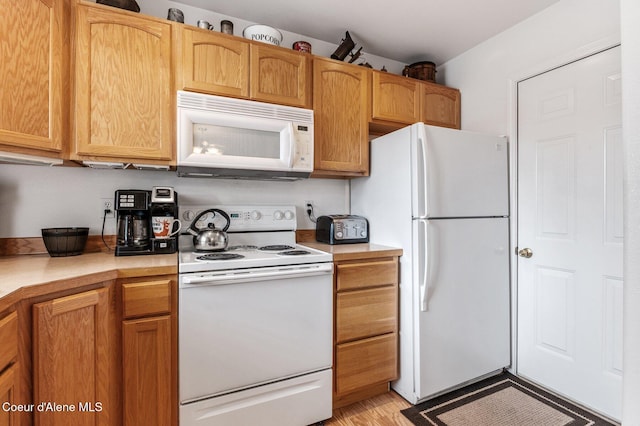 kitchen with white appliances, light countertops, and light wood-type flooring