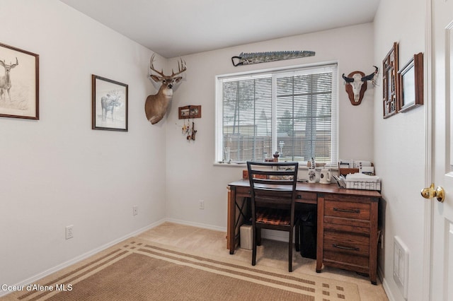 office space with baseboards, visible vents, and light carpet