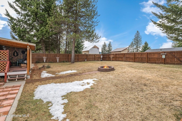 view of yard with a wooden deck, an outdoor fire pit, and a fenced backyard