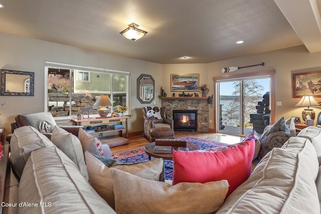 living area with a fireplace, baseboards, and wood finished floors