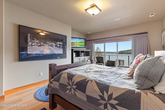 bedroom featuring visible vents, baseboards, and wood finished floors