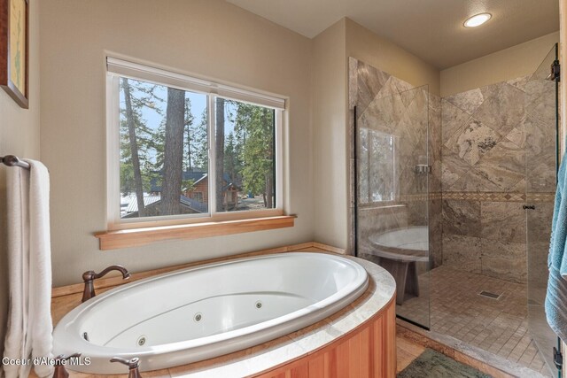 bathroom featuring a tile shower and a whirlpool tub