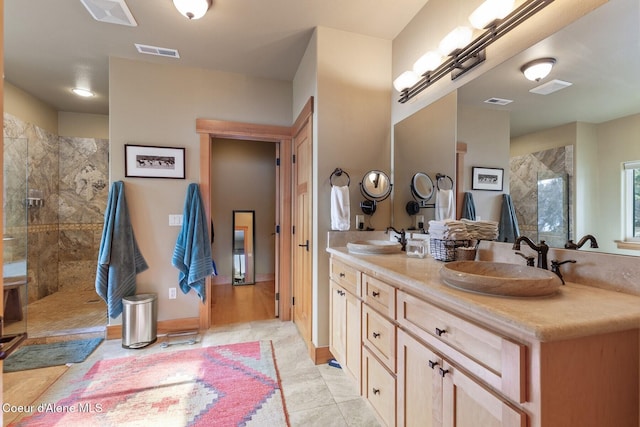 bathroom with visible vents, walk in shower, and a sink