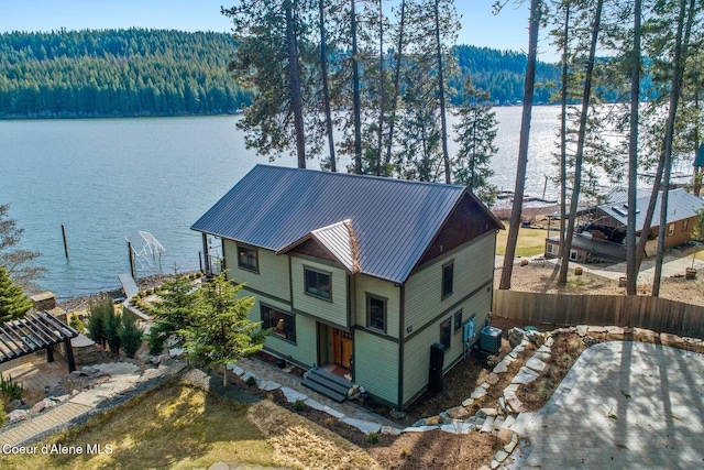 aerial view featuring a wooded view and a water view