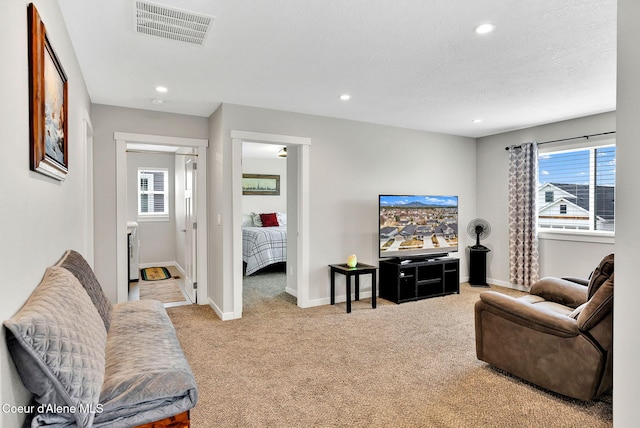 carpeted living room with recessed lighting, visible vents, baseboards, and a textured ceiling