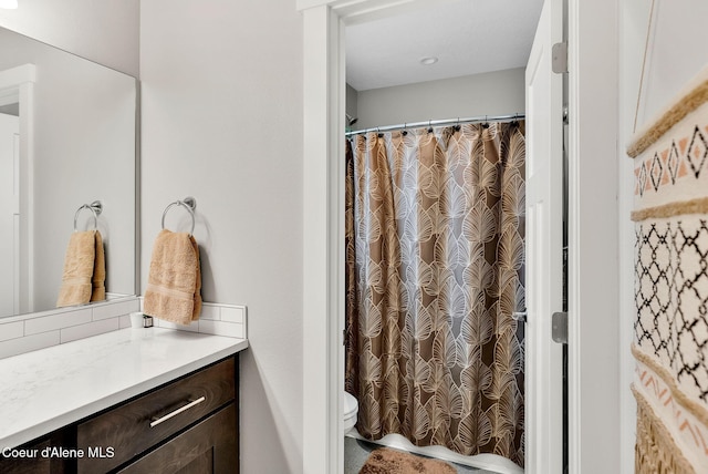 full bathroom featuring vanity, a shower with shower curtain, and toilet