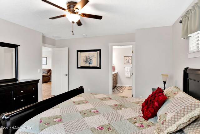 bedroom with ceiling fan, carpet flooring, connected bathroom, and a textured ceiling