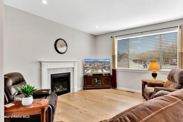 living room featuring recessed lighting, baseboards, a tile fireplace, and hardwood / wood-style flooring