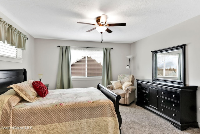 bedroom with a textured ceiling, multiple windows, and light carpet