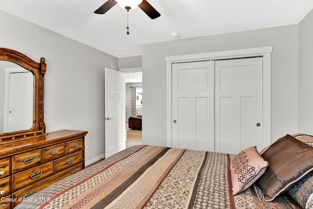 carpeted bedroom featuring a closet, baseboards, a textured ceiling, and ceiling fan