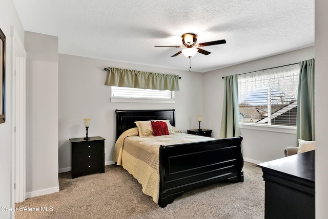 carpeted bedroom with baseboards, multiple windows, and a textured ceiling