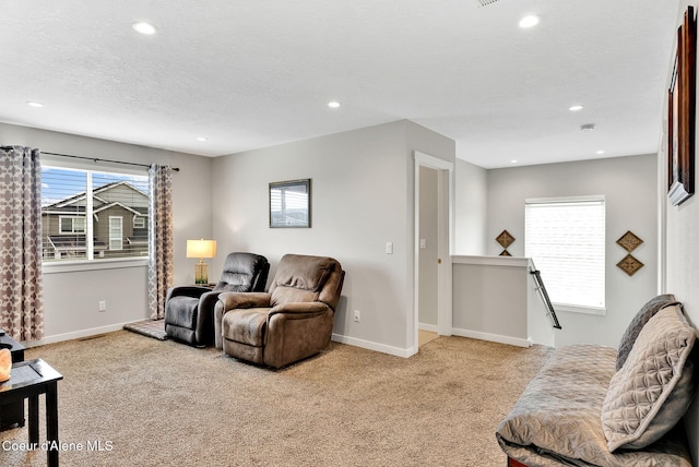 living area with recessed lighting, carpet, baseboards, and a textured ceiling