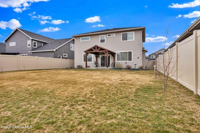 rear view of house featuring a gazebo, a fenced backyard, and a yard