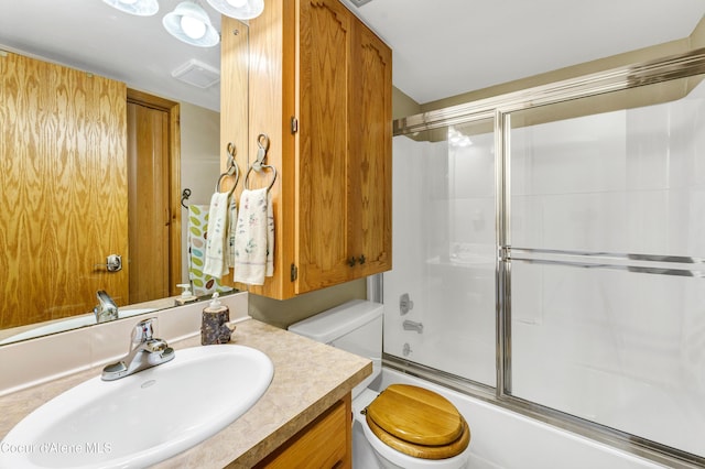 bathroom featuring vanity, toilet, visible vents, and combined bath / shower with glass door