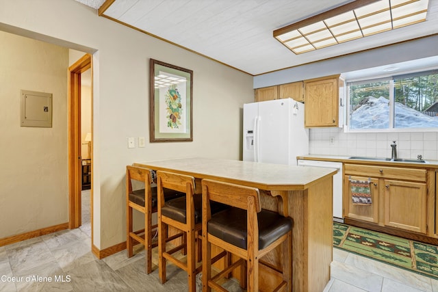 kitchen with a breakfast bar, electric panel, decorative backsplash, white appliances, and a sink