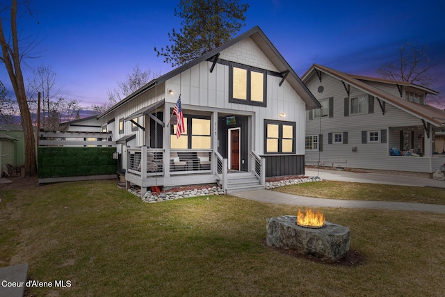 view of front of house featuring a lawn, board and batten siding, and an outdoor fire pit