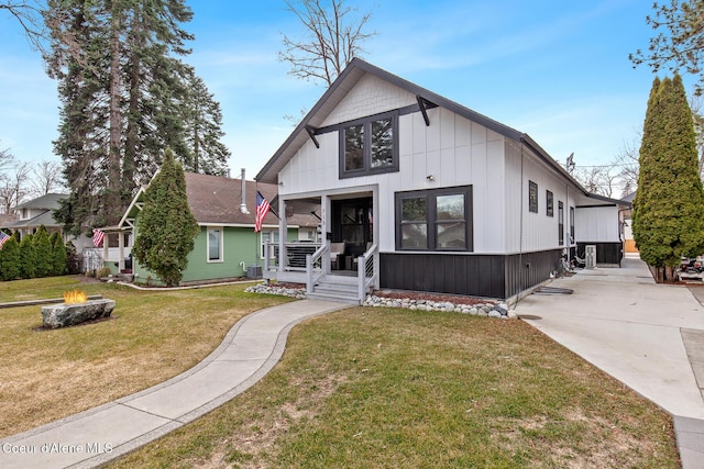 view of front of property with a front lawn, a porch, and an outdoor fire pit