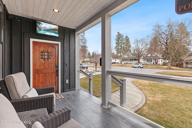 sunroom / solarium with a residential view and wooden ceiling