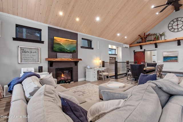 living area with wooden ceiling, a barn door, and wood finished floors