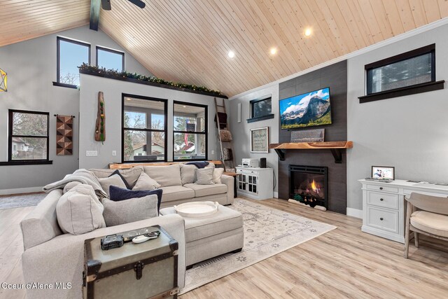 living area with baseboards, wooden ceiling, a fireplace, light wood-style floors, and high vaulted ceiling